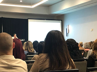 Conference room with rows of people listening to a presentation